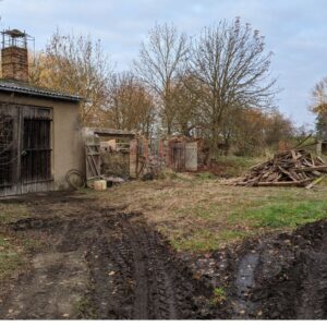 Baustelle Außengelände mit alten Scheunen und Bäumen in der Mecklenburgischen Seenplatte